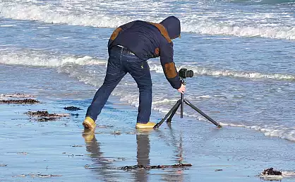 Fotograf beim fotografieren der Ostseewellen
