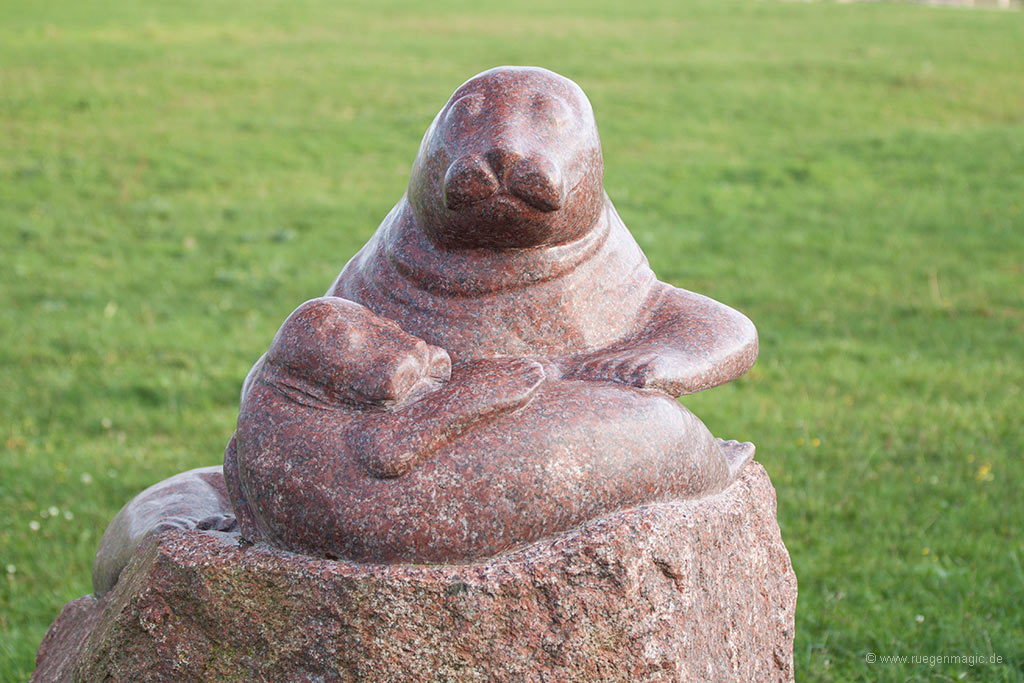 Steinskulptur Seehund mit Seehundbaby im Kurpark Glowe